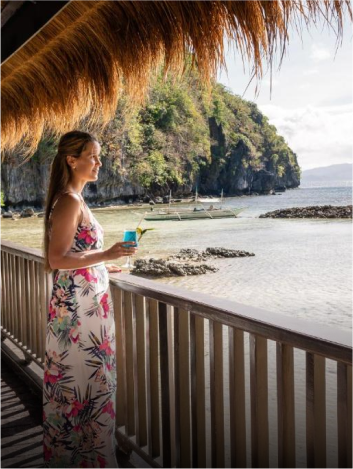 Woman looking out into the sea from a Deluxe Seaview Room at Miniloc.